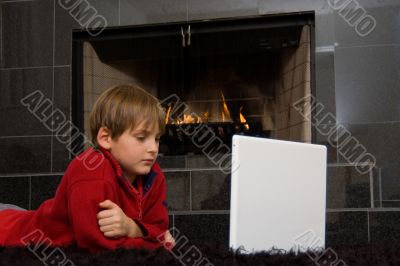 Boy at Fireplace on Computer.