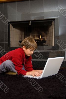 Boy at Fireplace on Computer.