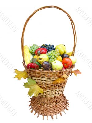 wooden basket with autumn harvest fruit vegetables and leaves isolated