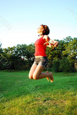 Happy woman jumping on grass