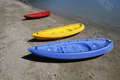 colorful kayaks on beach by turquoise waters