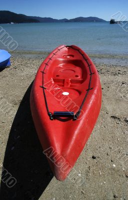 colorful kayaks on beach by turquoise waters