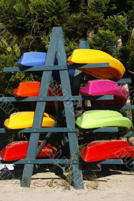 colorful kayaks on beach by turquoise waters