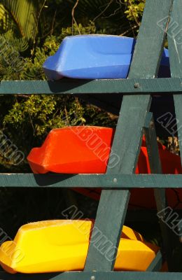 colorful kayaks on beach by turquoise waters