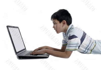 young boy doing homework on a laptop