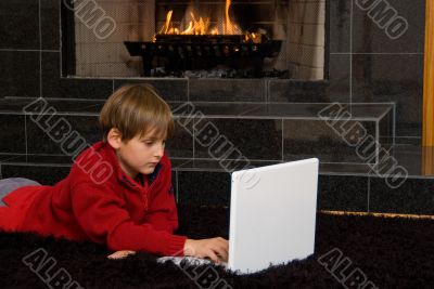 Boy at Fireplace on Computer.