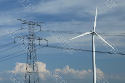 a windturbine close to a electric pylon