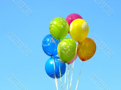 Bunch of colored party balloons against blue sky