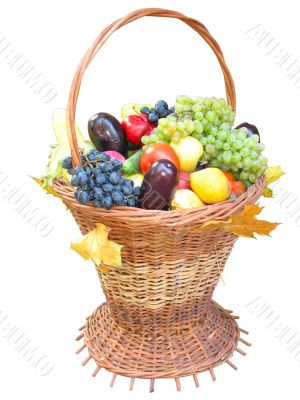 wooden basket with autumn harvest fruit vegetables and leaves isolated