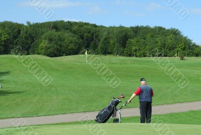 Senior  holding a golf caddie