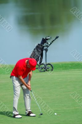 Golfer putting on green golf course