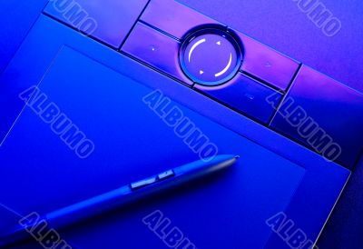 drawing tablet with pen in blue light