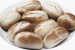 freshly baked white bread rolls on white