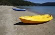 colorful kayaks on beach by turquoise waters