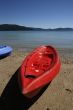 colorful kayaks on beach by turquoise waters