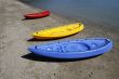 colorful kayaks on beach by turquoise waters