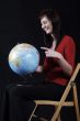 girl in red top pointing at globe