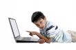 young boy doing homework on a laptop