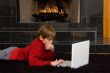 Boy at Fireplace on Computer.