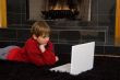 Boy at Fireplace on Computer.