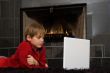 Boy at Fireplace on Computer.