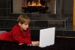 Boy at Fireplace on Computer.