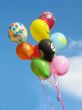 Bunch of colored party balloons against blue sky