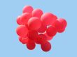 Bunch of red party balloons against blue sky