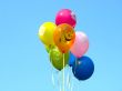 Bunch of colored party balloons against blue sky