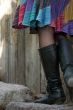 young woman high black boots with colorful skirt