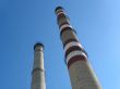 Two industrial chimneys with no smoke over blue sky